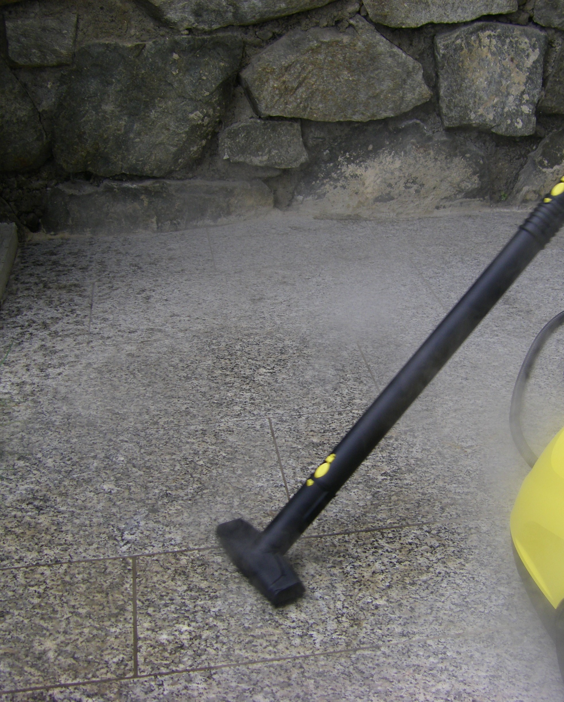 Steam cleaner in action on stone steps.